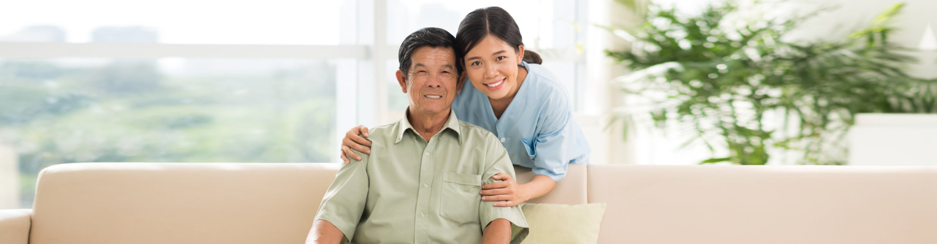 elder man sitting on a couch with caregiver